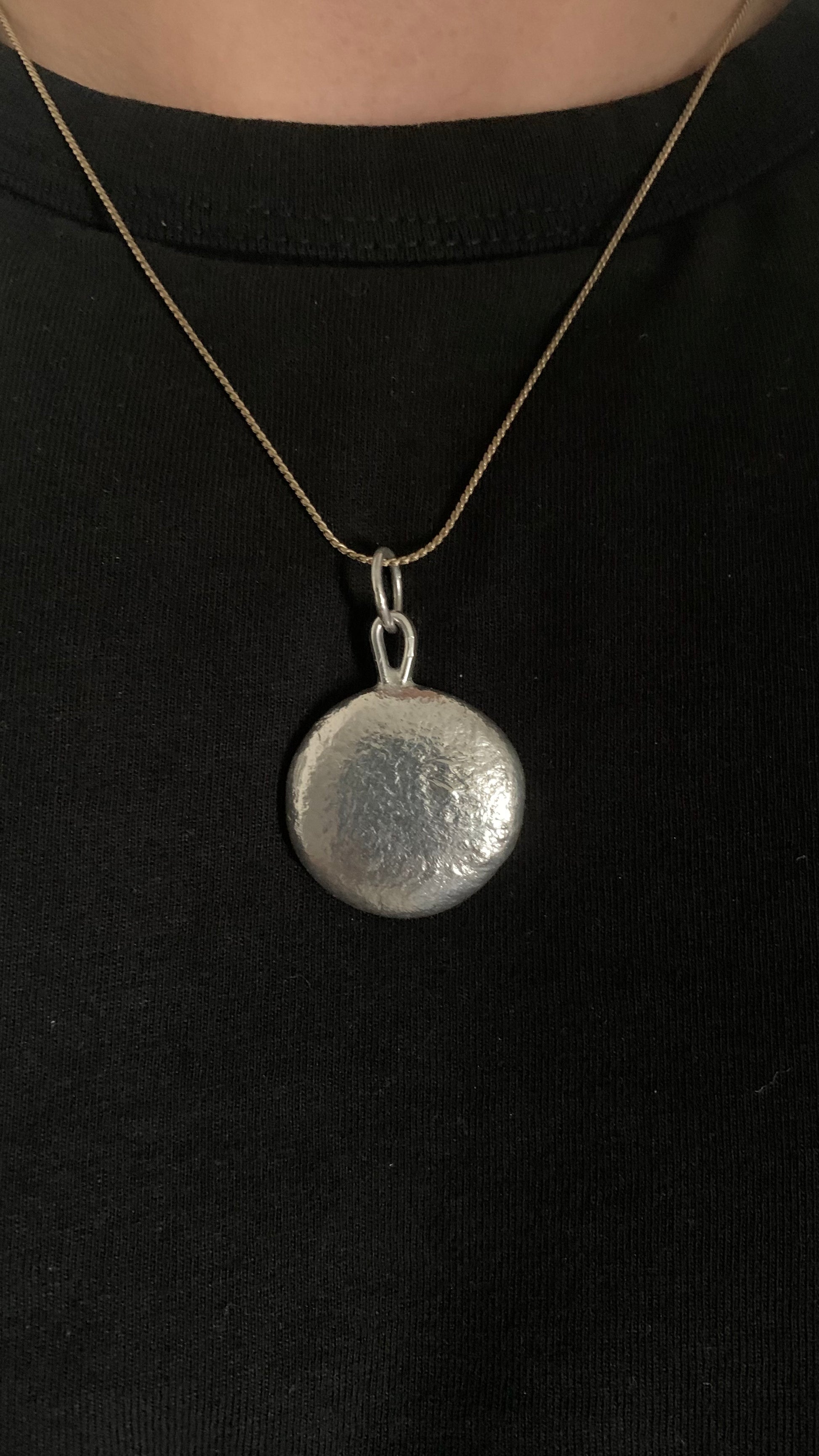 Frontside image of a one ounce silver pendant being worn