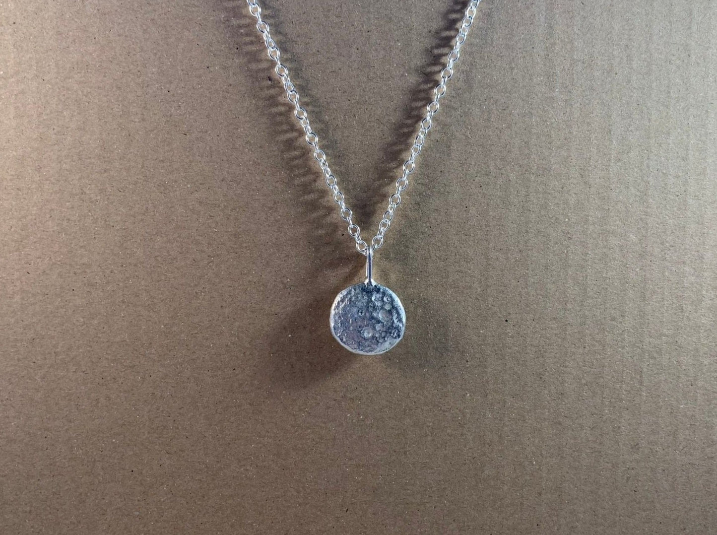 Backside image of half ounce pendant on a chain 