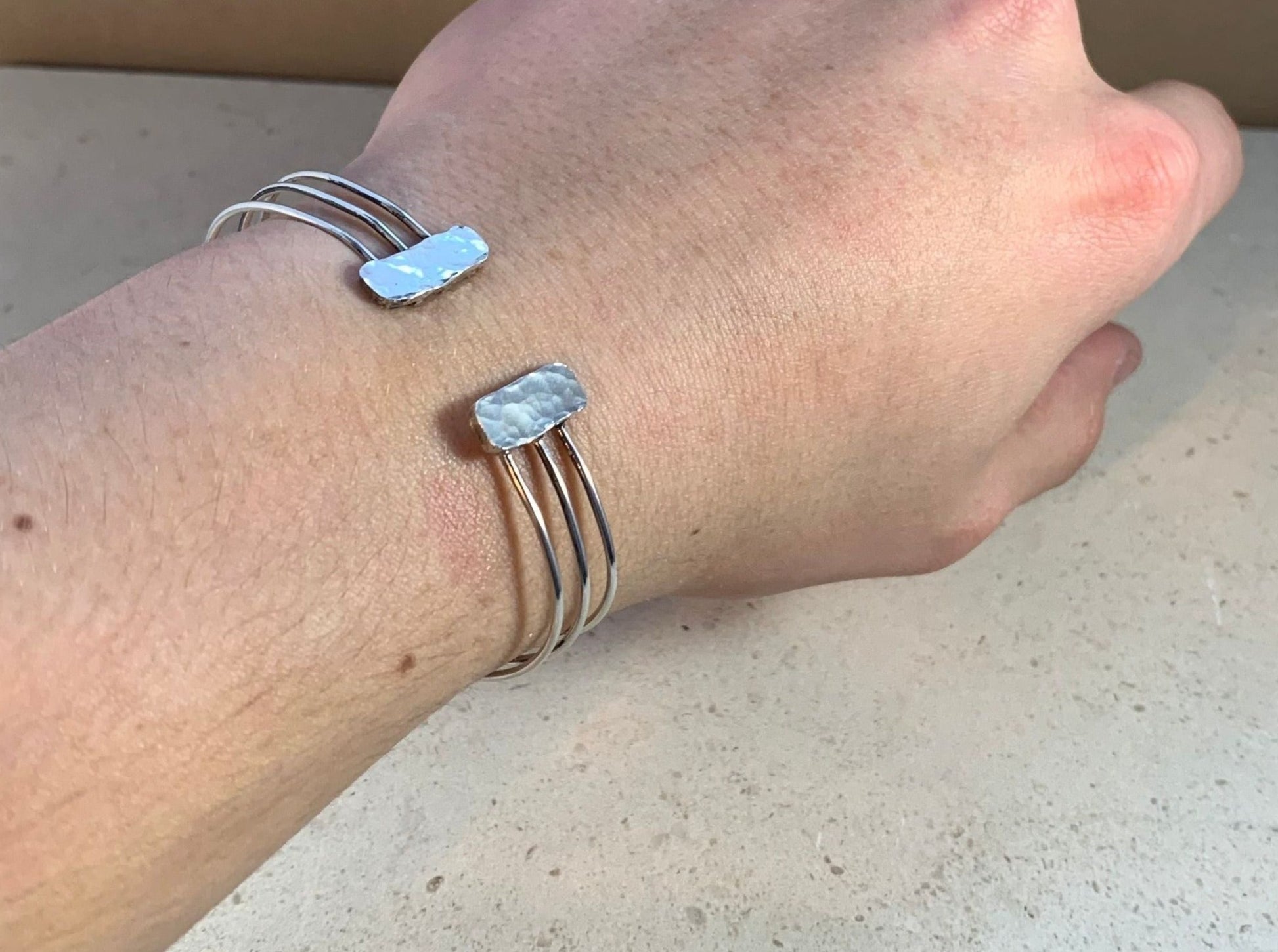 A silver bracelet being worn