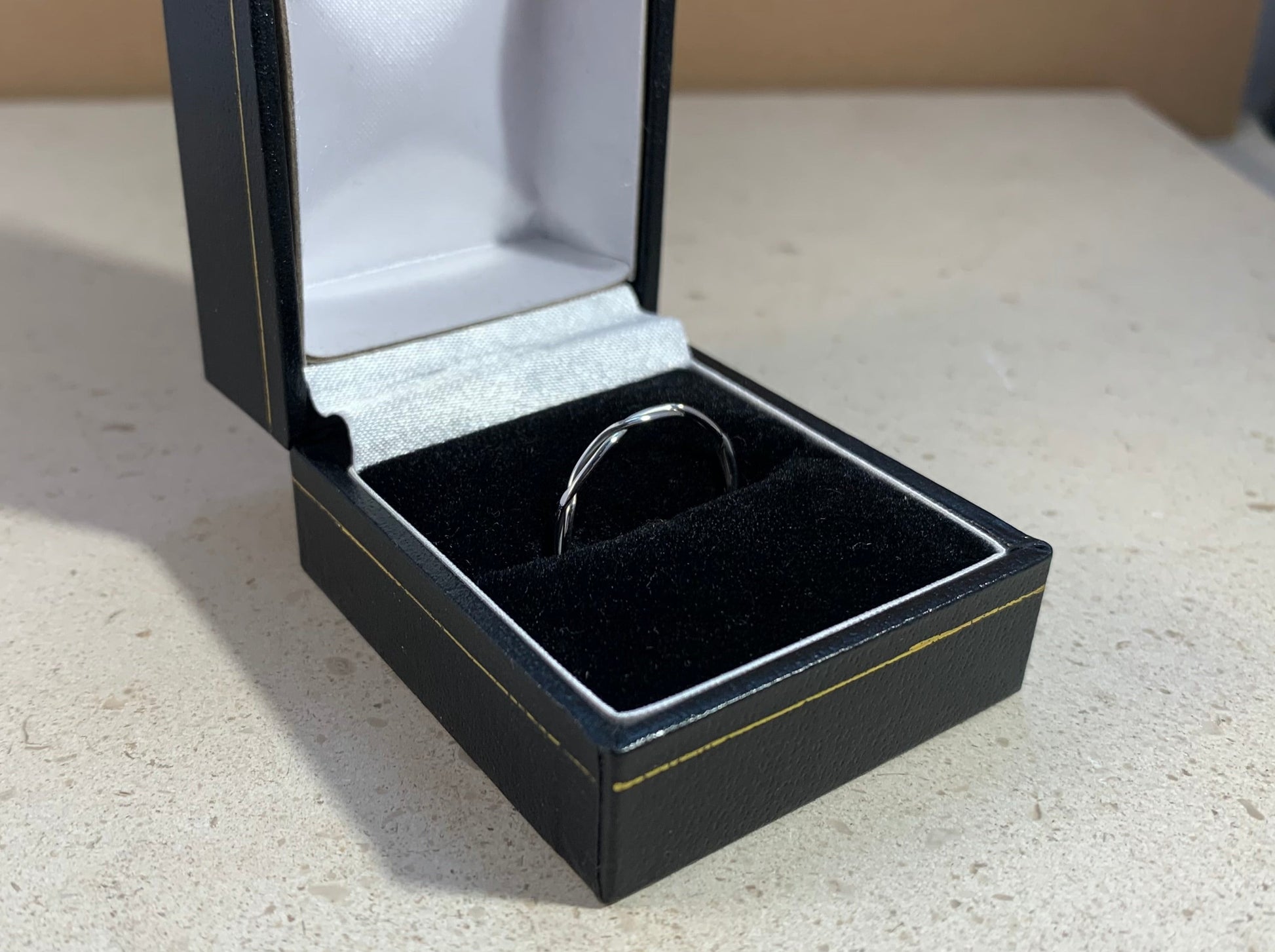 Twisted silver ring in a ring box, right angle 