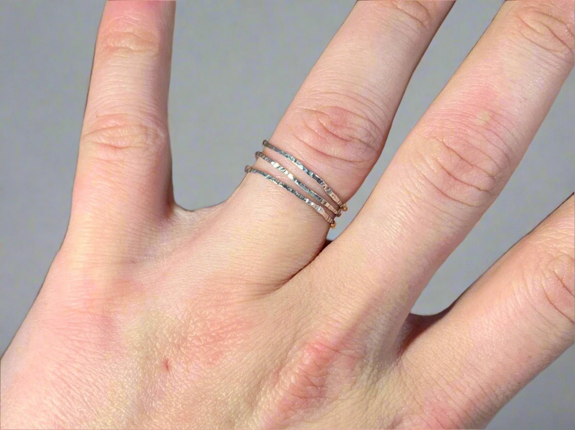 Hammered stacking rings being worn on ring finger 