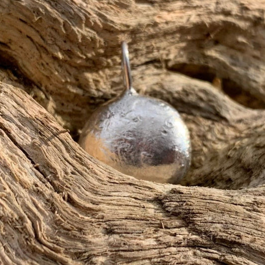 Half ounce pendant on a log