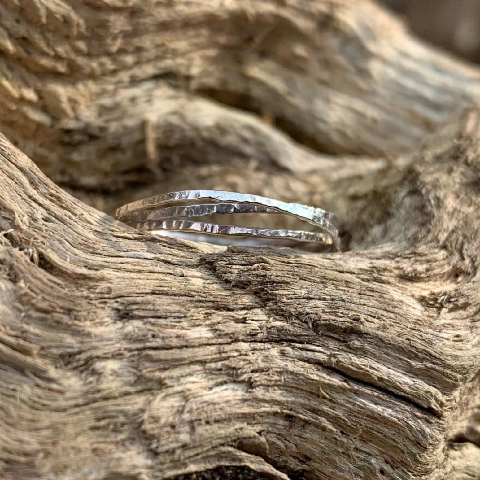 Hammered stacking rings on a log  